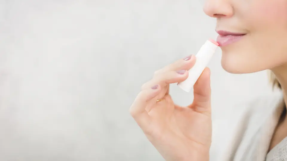 Donna che applica un balsamo labbra
